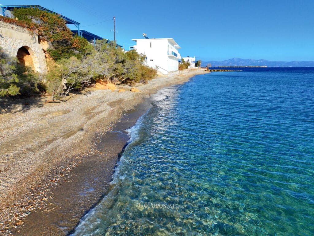 Pebble shoreline with calm, clear water along the coast at Drios Beach, Paros.