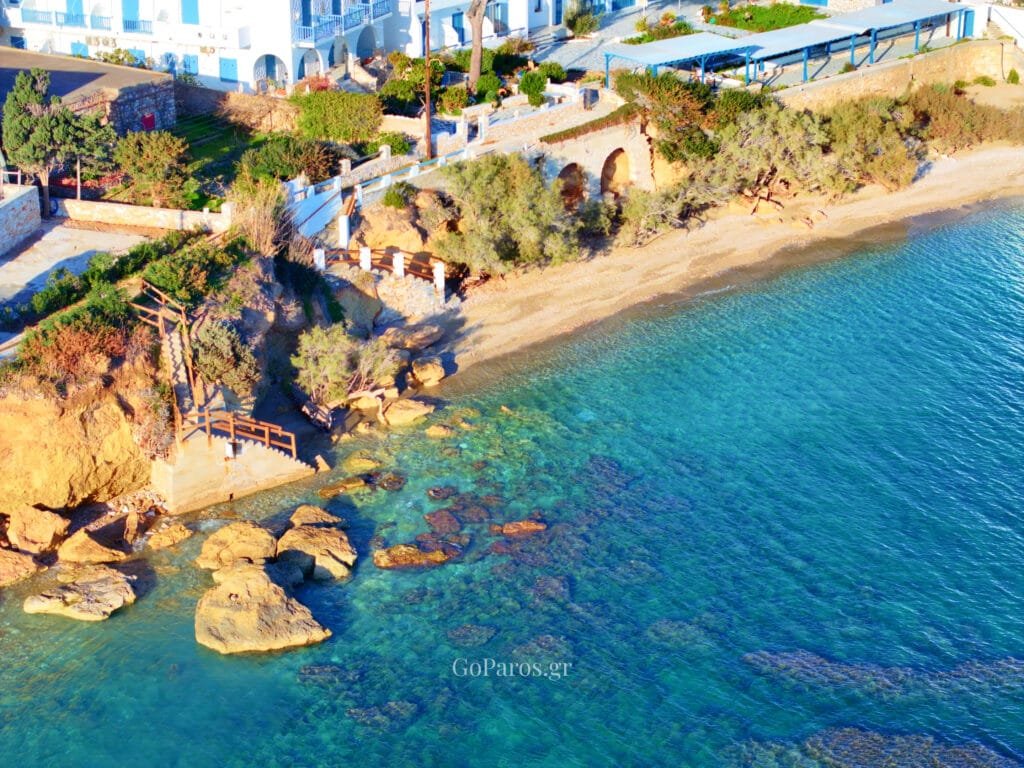 Rocky shoreline with vivid turquoise water and coastal steps near Drios Beach, Paros.