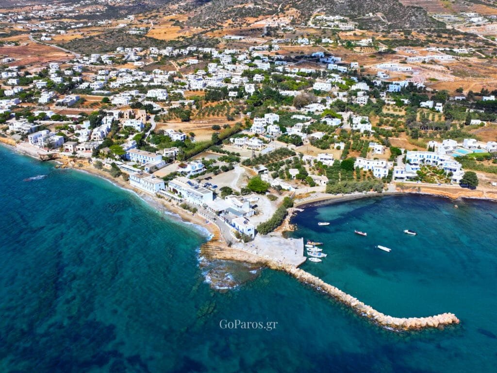 Drios, Paros, blue door and shutters with potted plants and a stone millstone in the foreground