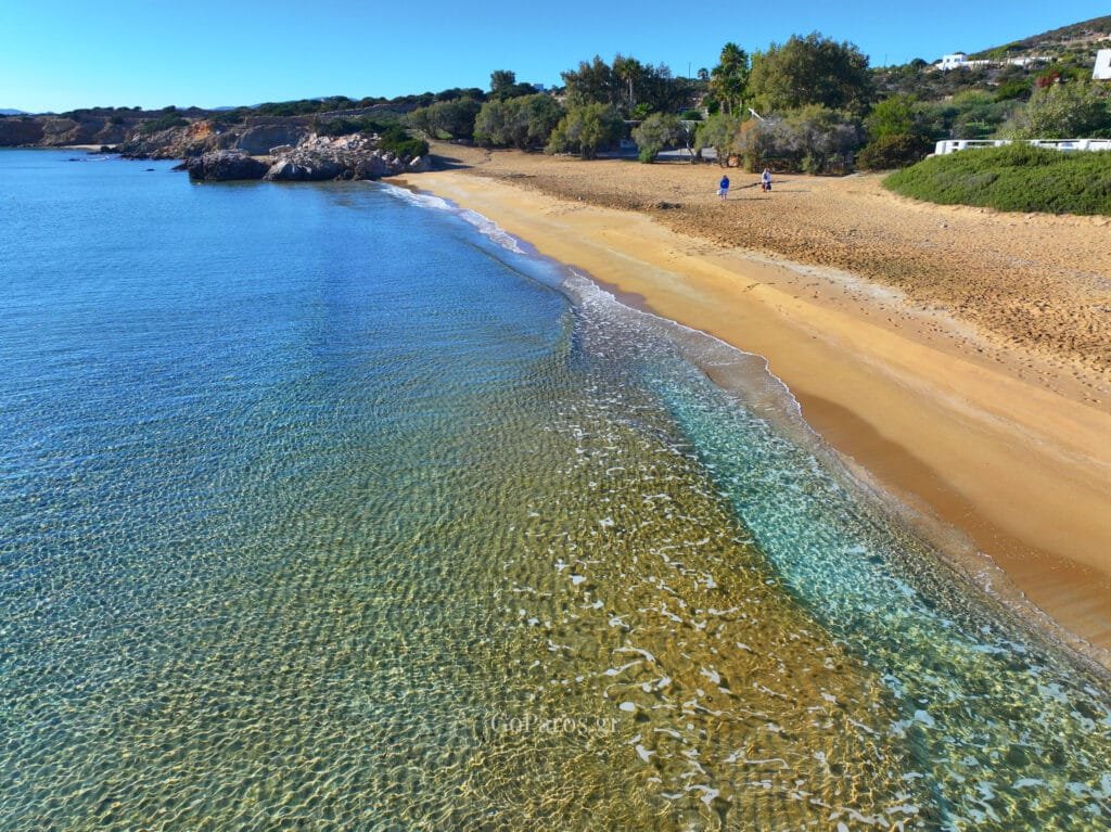 Clear shallow water at Faraggas Beach in Paros, seen along the shoreline with gentle waves on the sand.