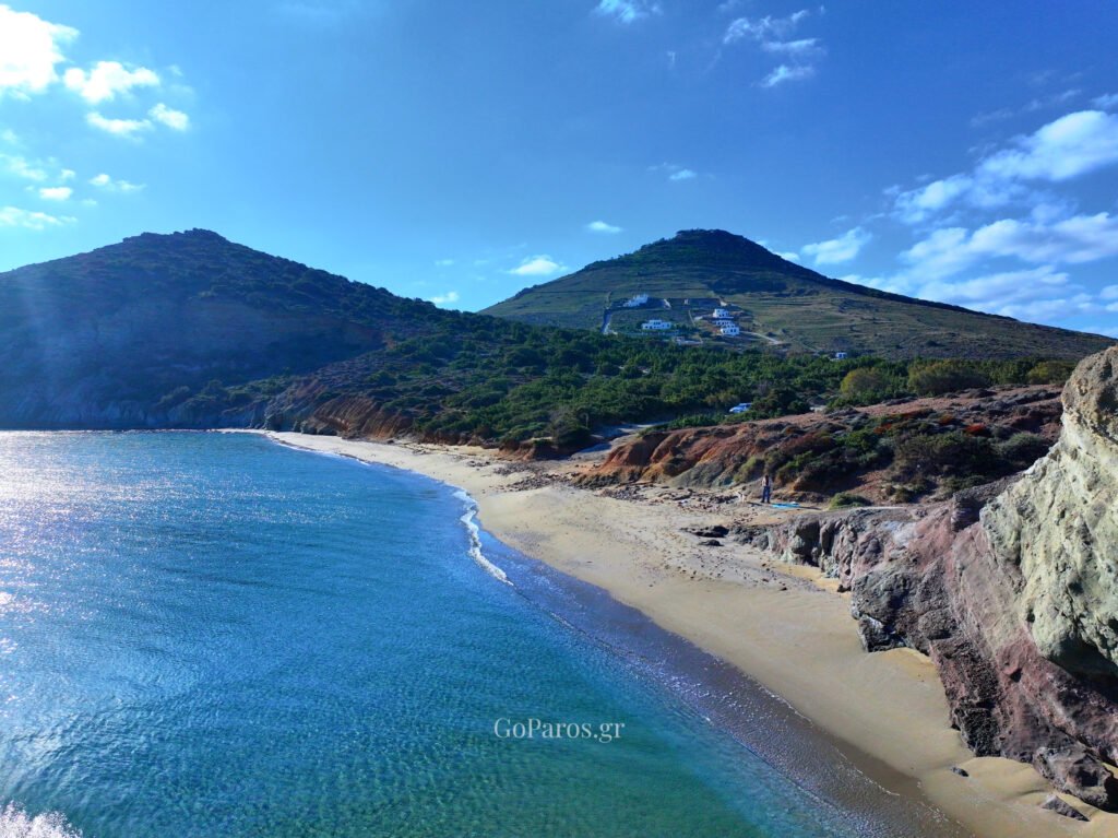 View along the shoreline with clay cliffs and clear water at Kalogeros Beach, Paros.