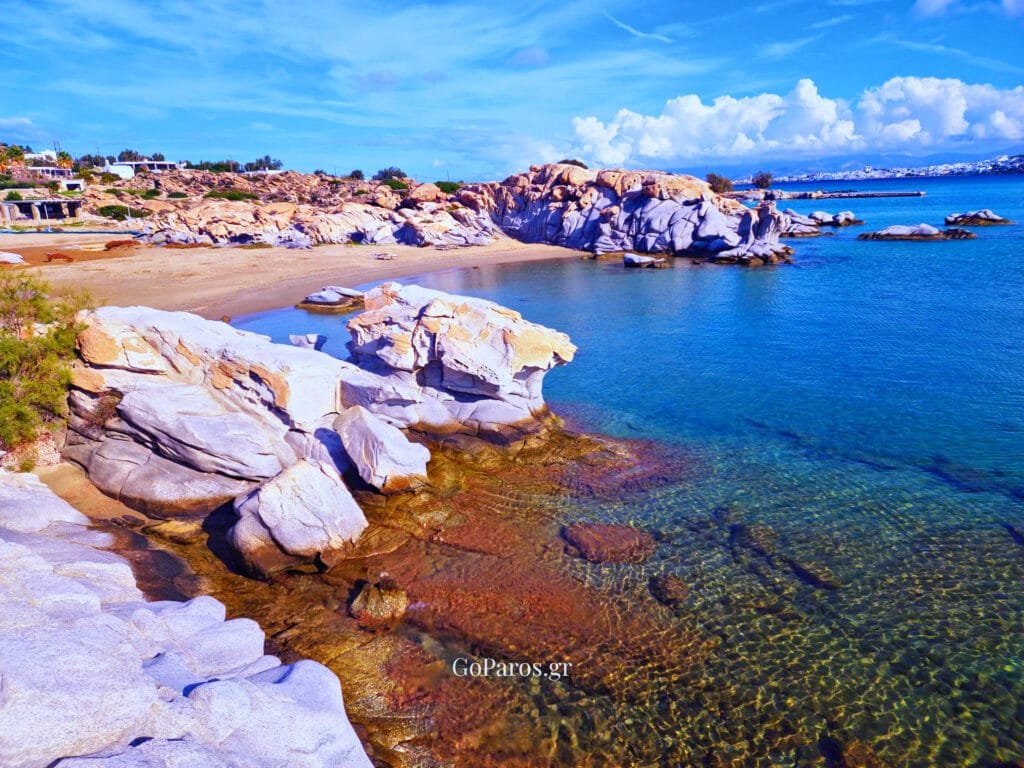 Top-down drone view of Kolymbithres Beach, Paros showing a tiny sandy bay between granite rocks and shallow water