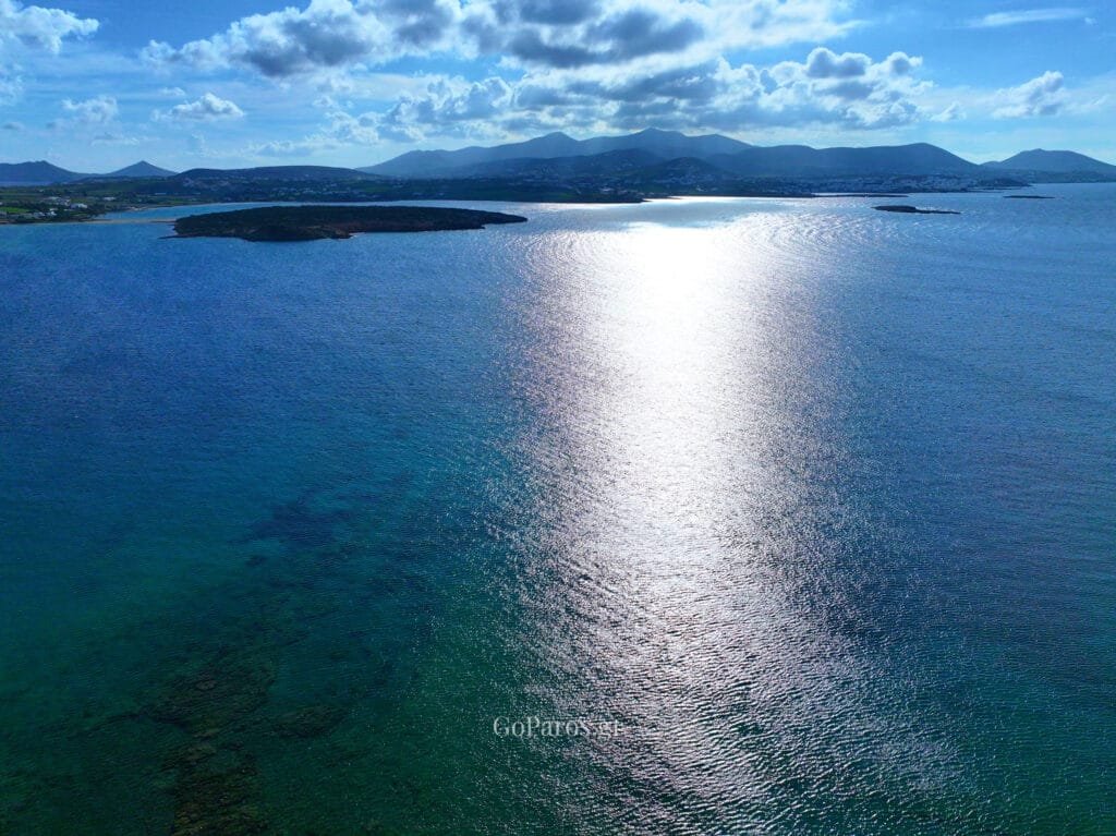 Laggeri Beach, Paros, aerial view of a bay and sun glitter on the water.