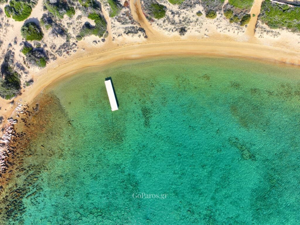 Laggeri Beach, Paros, view over a rocky headland and sheltered bay with clear blue-green water.