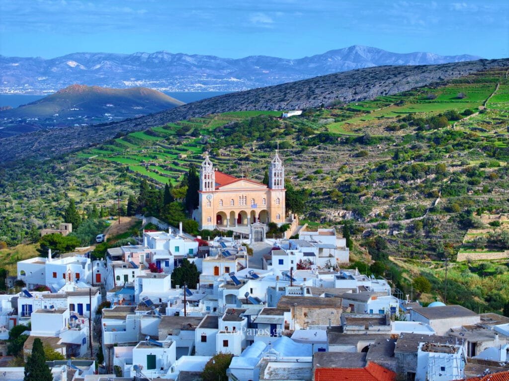 Lefkes, Paros, elevated view of the village rooftops with the Agia Triada church and terraced hills behind