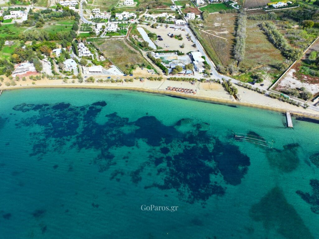 Livadia Beach, Paros, aerial view of the shoreline with a pier and floating water sports lines in the clear shallow sea