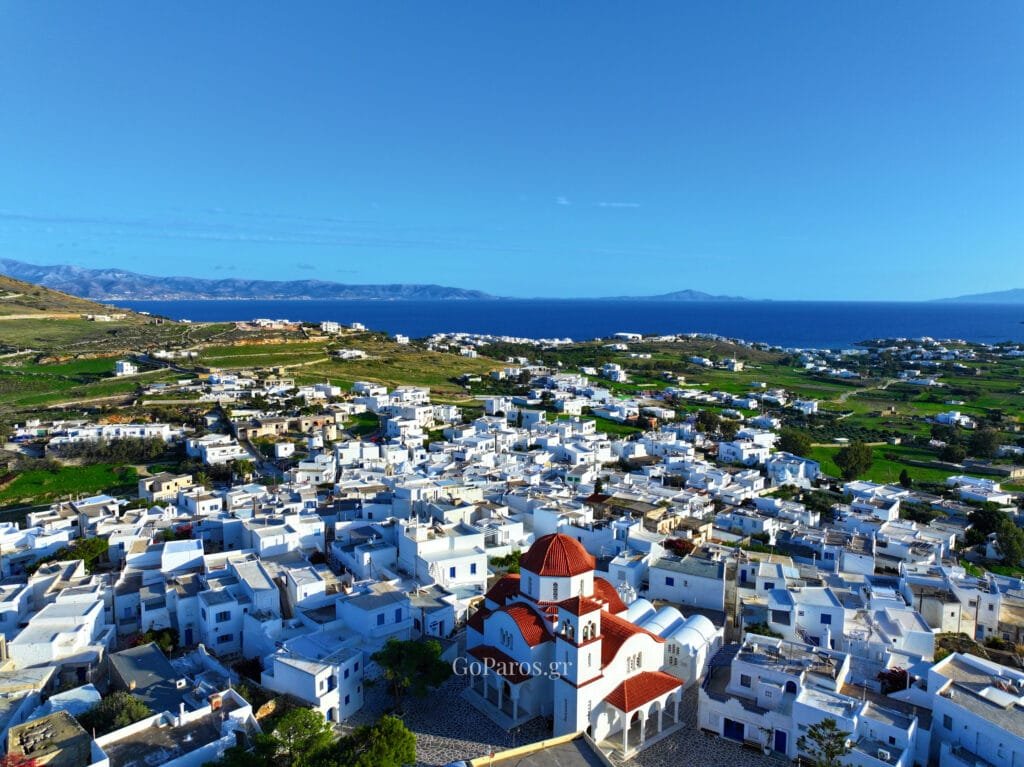 Marpissa, Paros, aerial view of the red-domed church above white rooftops with the sea on the horizon