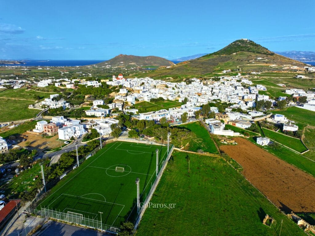 Marpissa, Paros, aerial view of the village with a soccer field in the foreground and hills rising behind