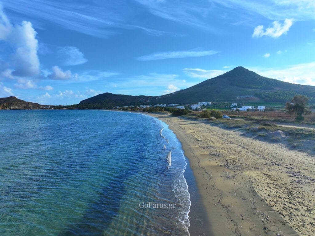 Wide view of Molos Beach shoreline with mountain backdrop, Paros.