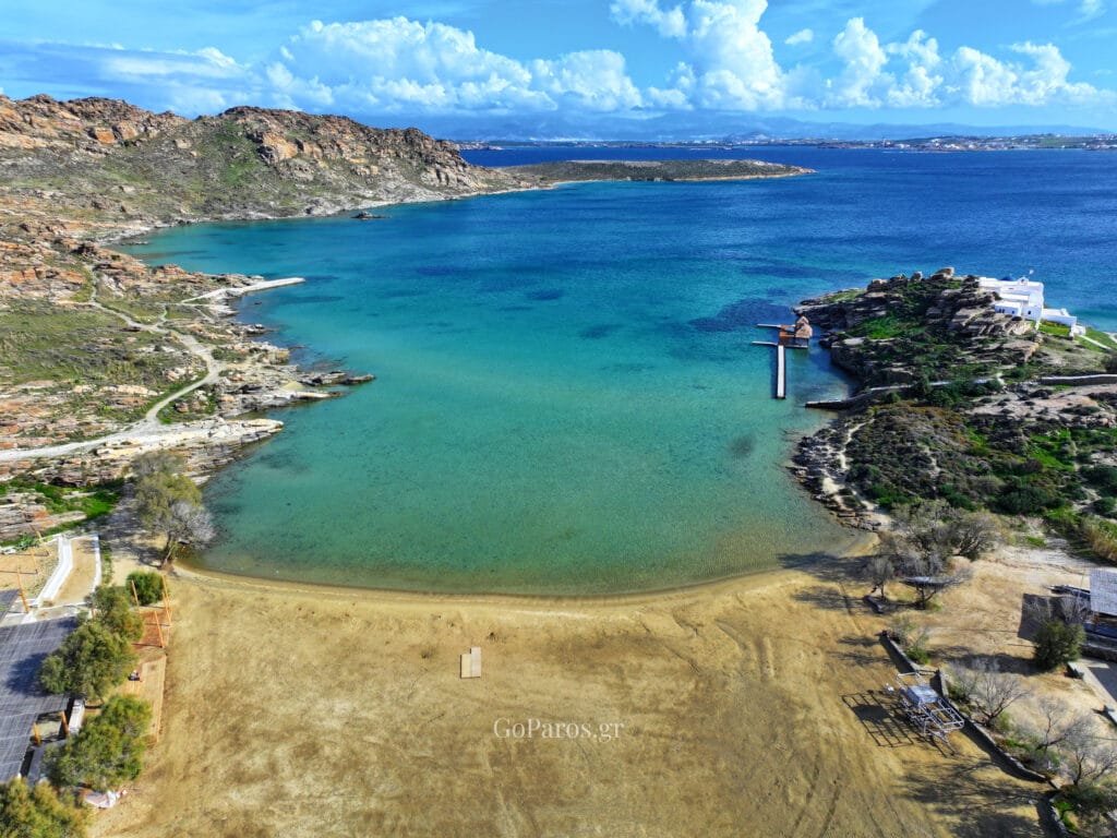 wide aerial view of monastiri beach bay in paros, with dock and clear water