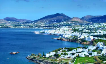 Parikia, Paros, panoramic view of the coastline and bay with whitewashed town and hills in the background