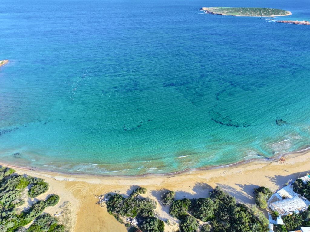 Small sandy cove with clear shallow water in Santa Maria, Paros