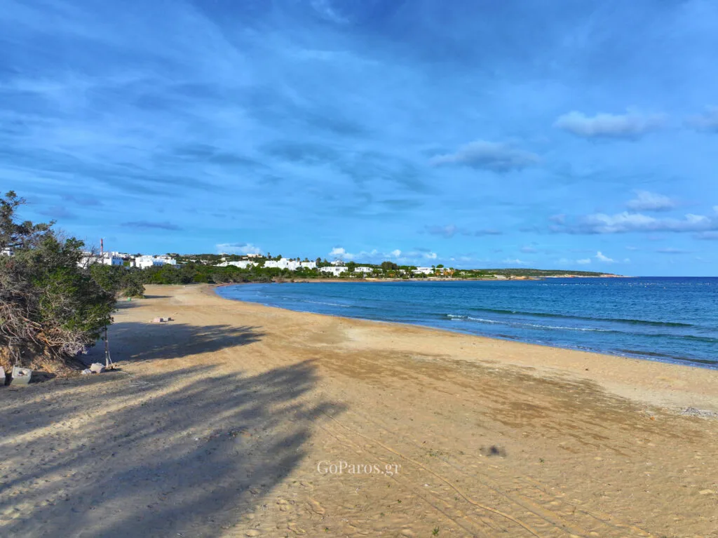 Wide view of a curved sandy beach and calm sea in Santa Maria beach, Paros