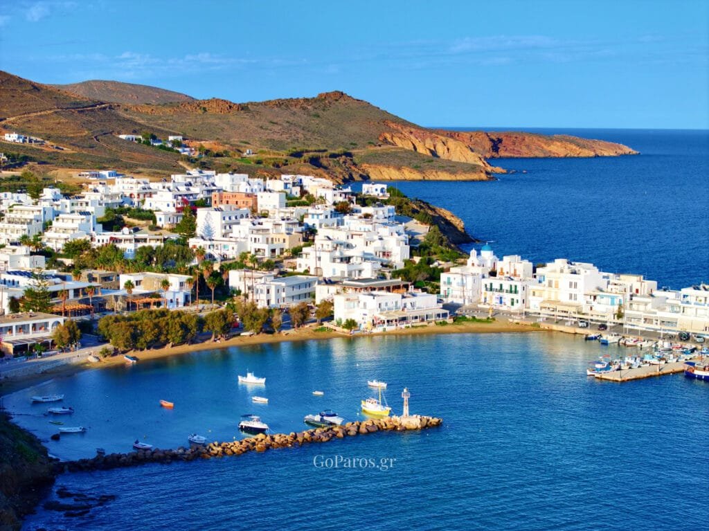Piso Livadi, Paros, bay and village view with breakwater and boats in the water.