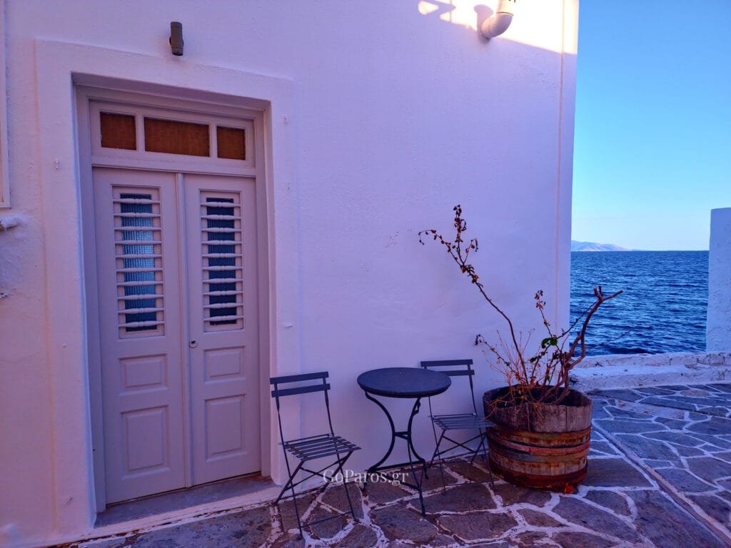 Piso Livadi, Paros, narrow arched passage with stone paving, a white staircase, and potted plants.