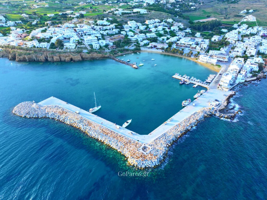 Piso Livadi, Paros, aerial view of the harbor breakwater and waterfront with boats in turquoise water.
