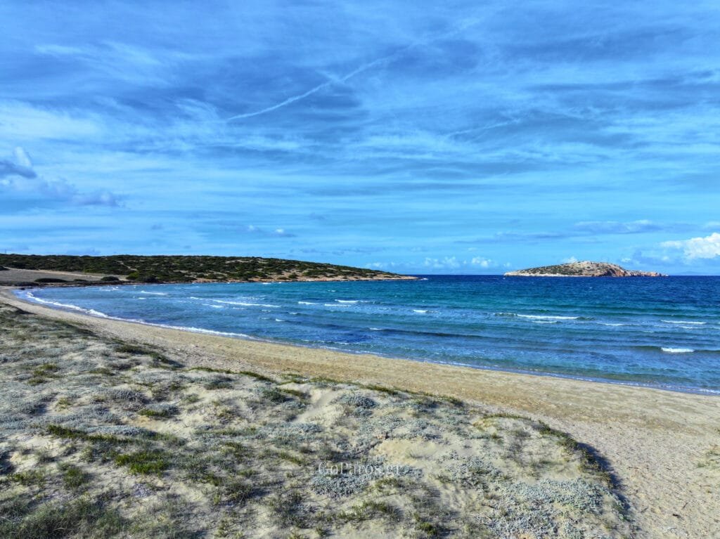 Platia Ammos Beach, Paros, aerial of a small cove with an eroded cliff, an abandoned building, and green-blue water