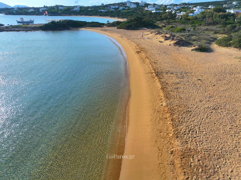 Small Santa Maria Beach, Paros, top-down aerial view of a sandy cove framed by rocky headlands and clear water.