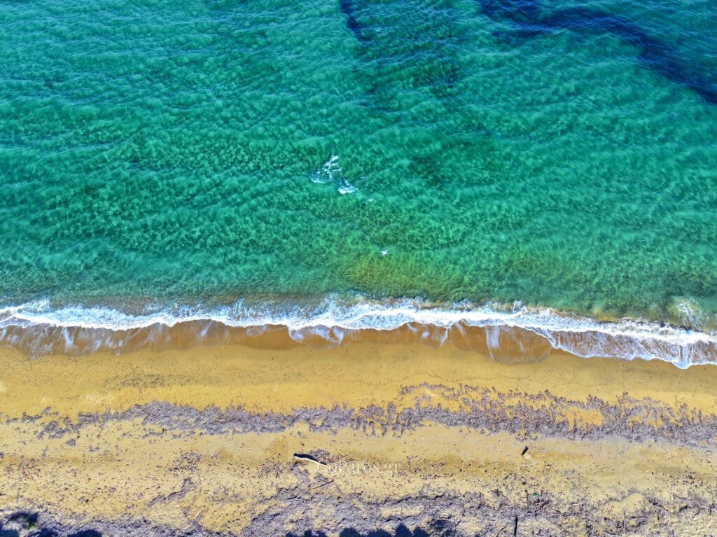 Calm, clear shallows along the sandy shore at Tsoukalia Beach, Paros.