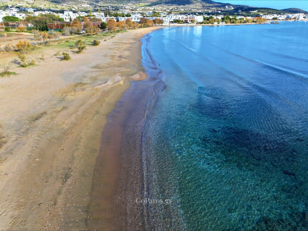 Agios Nikolaos Beach, Aliki, Paros, beach kitesurf station and tire tracks on sand in late afternoon light