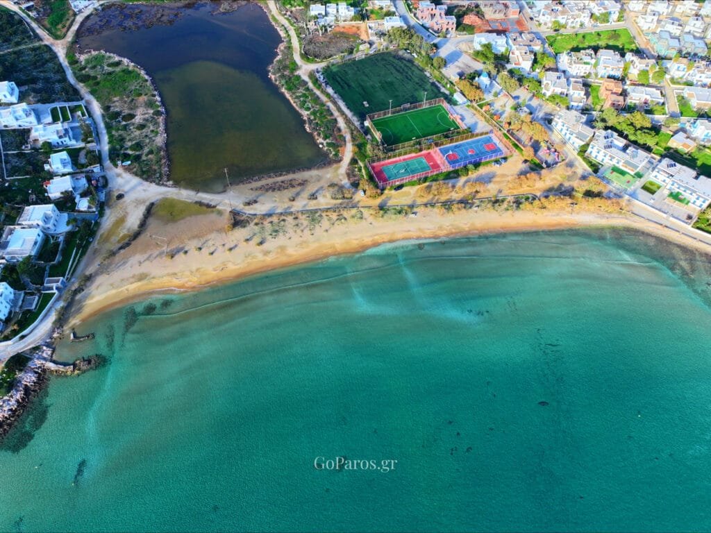 Agios Nikolaos Beach, Aliki, Paros, top-down view of small waves meeting sand with a person near the waterline