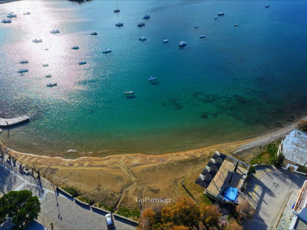 Aliki Beach, Paros, drone view of the curved coastline with turquoise sea and coastal fields