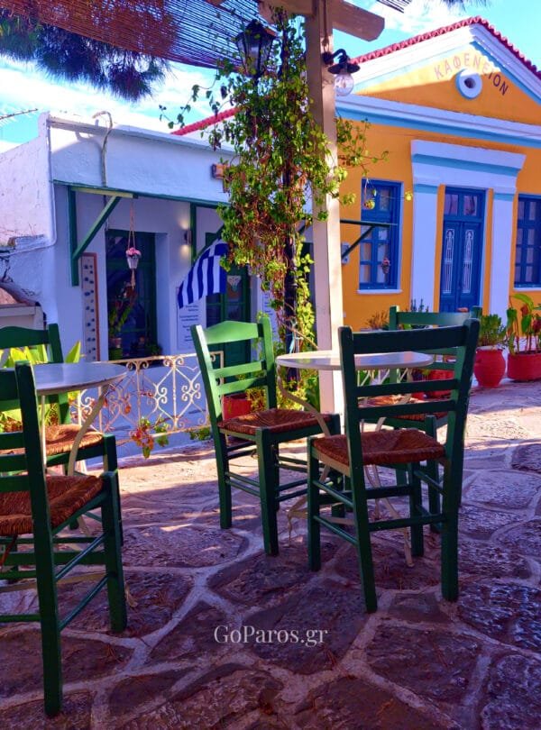 Lefkes, Paros, small cafe terrace with green chairs and colorful Cycladic buildings