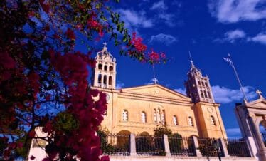 Lefkes, Paros, church facade with bougainvillea flowers against a deep blue sky