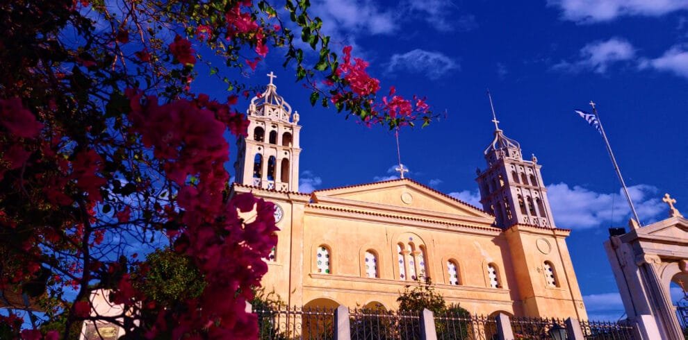Lefkes, Paros, church facade with bougainvillea flowers against a deep blue sky