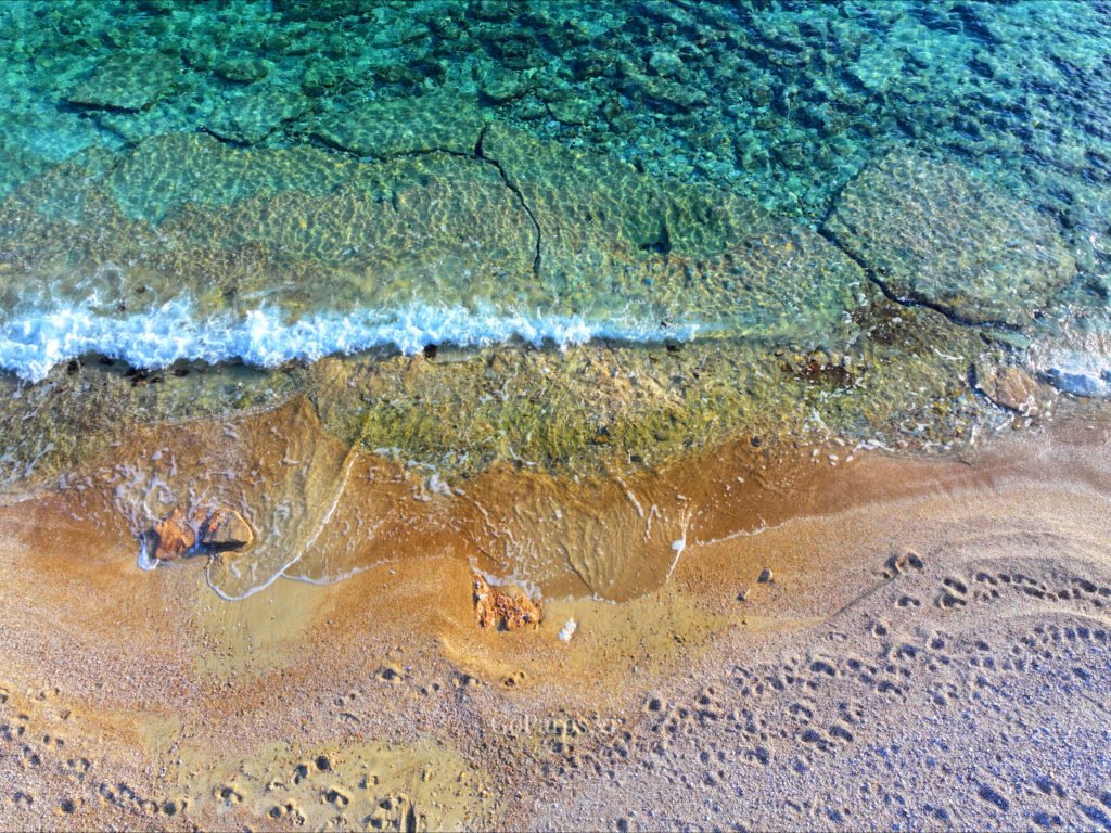 Makria Miti Beach, Paros, close-up view of crystal clear water over rocks at the shoreline