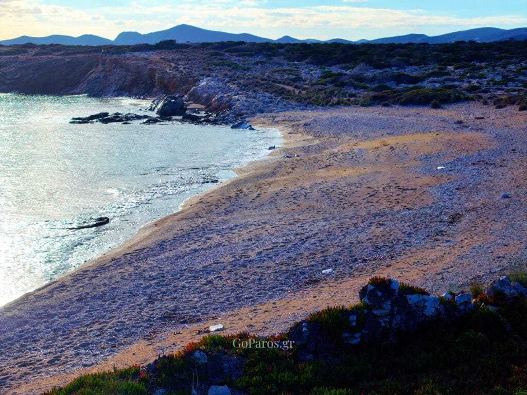 Makria Miti Beach, Paros, aerial view along the curved shore with rocky headland and hills in the background