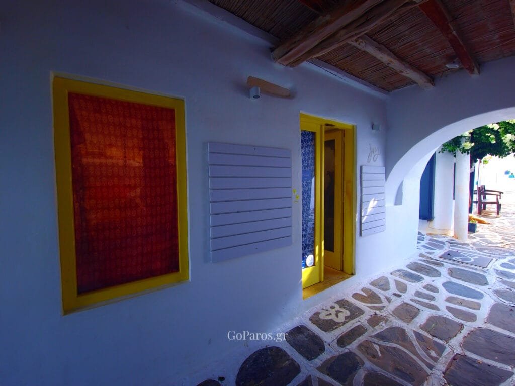 Naoussa, Paros, covered walkway with yellow doors and stone paving