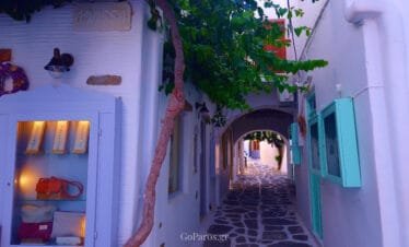 Naoussa, Paros, Cycladic alley with archway, shopfronts, and stone paving