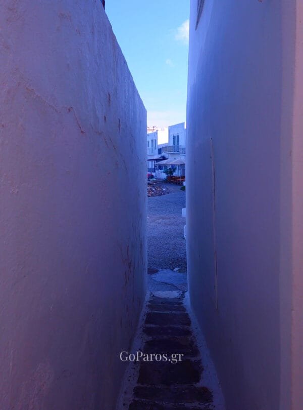 Naoussa, Paros, narrow passage between white walls leading toward a small square