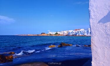 Paros coastline, view of whitewashed houses by the sea and rocky shoreline