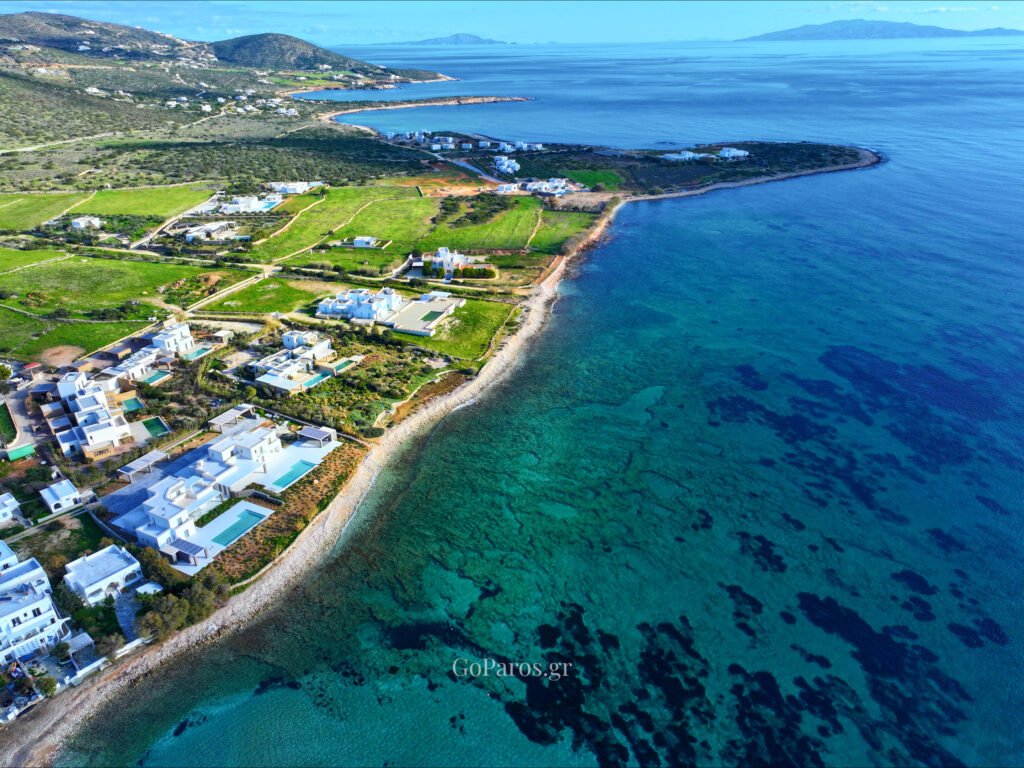 Aerial photograph of Piso Aliki Beach Paros showing white coastal villas and pristine blue waters