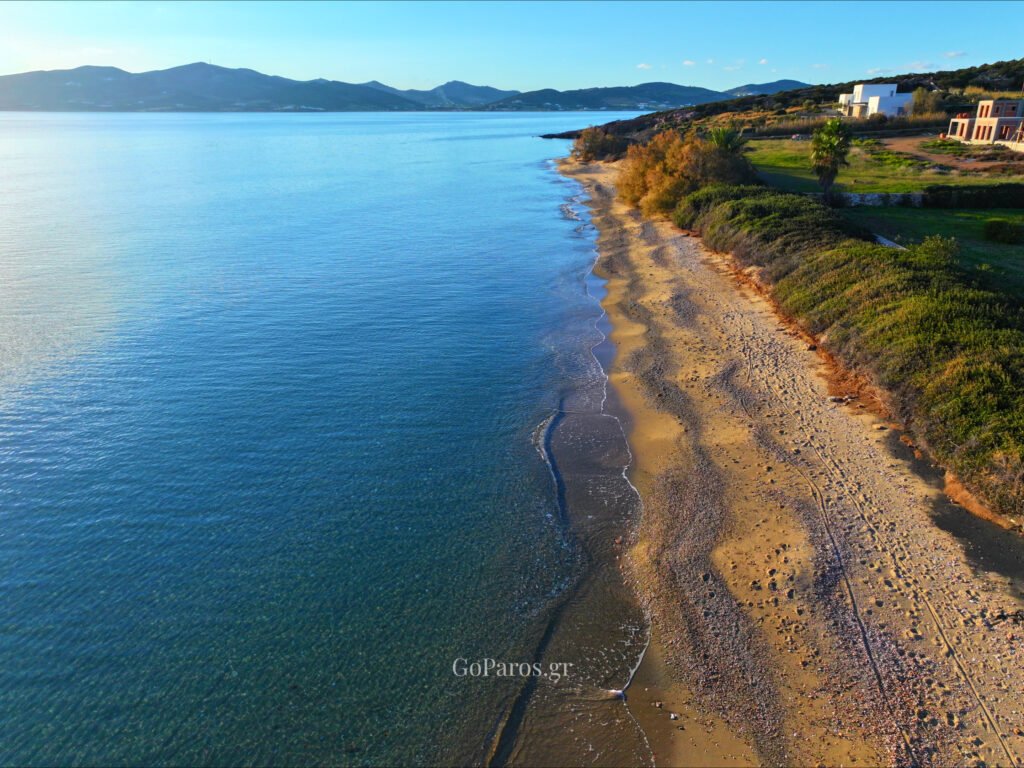 Voutakos Beach, Paros, aerial view of a quiet sandy beach with calm water and houses behind