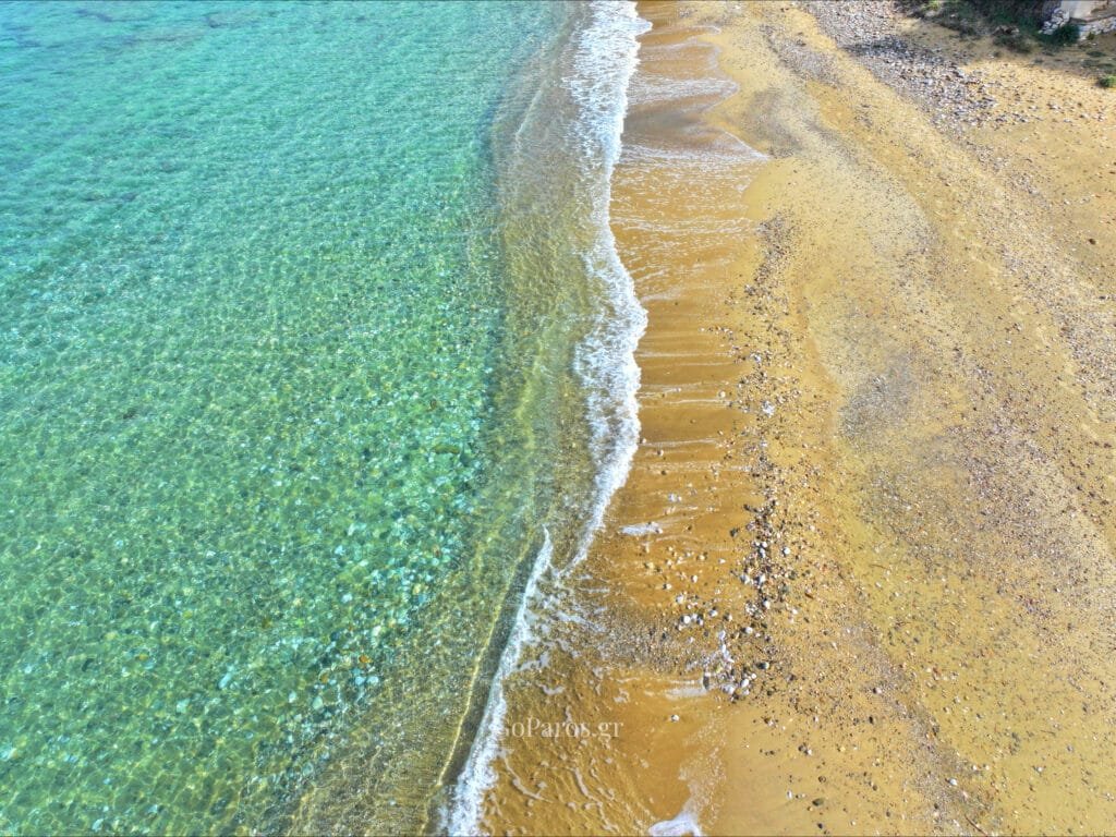 Clear water meeting the shoreline at Delfini Beach, Paros.