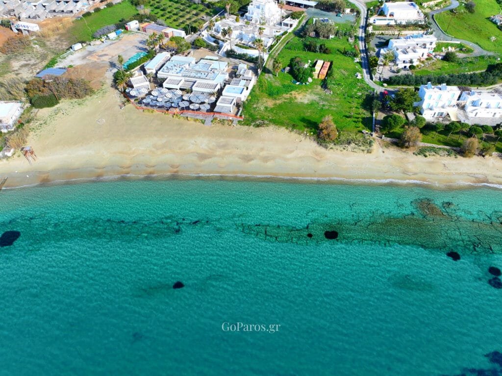 Aerial view of the turquoise water and beach club area along Krios Beach, Paros.