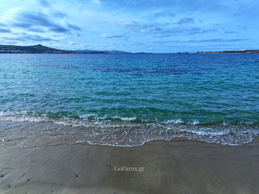 Small waves rolling onto the sand with open sea views at Krios Beach, Paros.