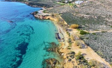 Aerial coastline view with cliffs and turquoise water at Marcello Beach, Paros.