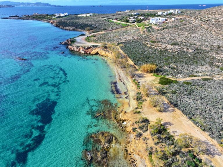 Aerial coastline view with cliffs and turquoise water at Marcello Beach, Paros.