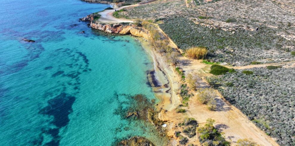 Aerial coastline view with cliffs and turquoise water at Marcello Beach, Paros.