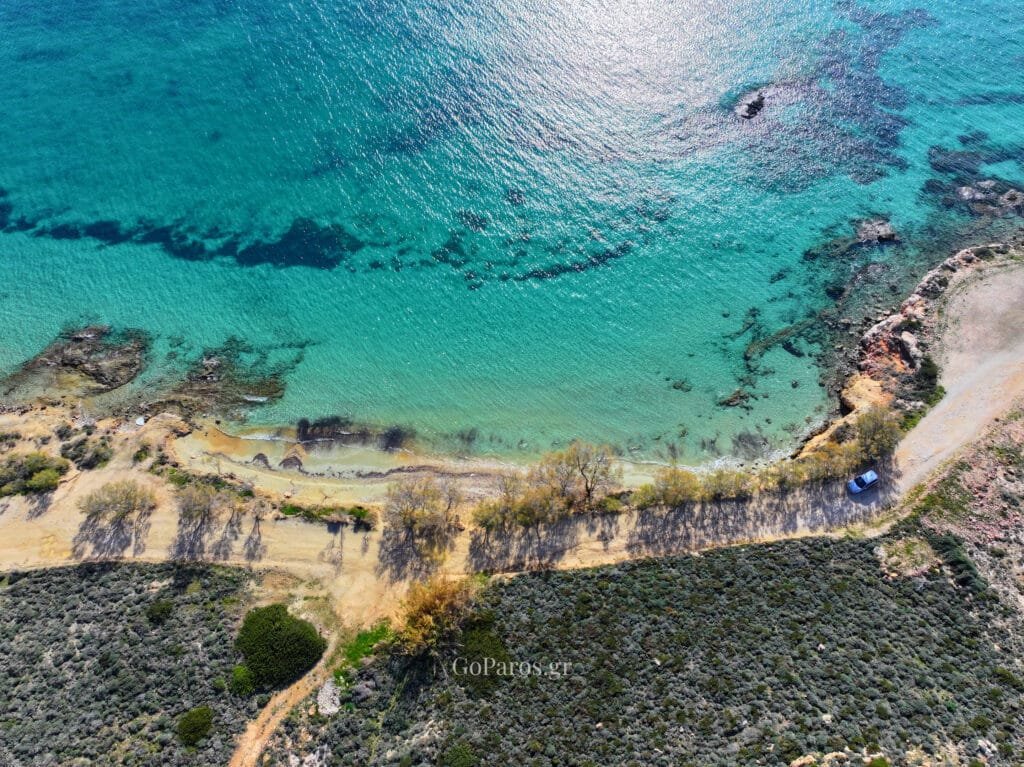 Aerial view of turquoise water and cove at Marcello Beach, Paros.