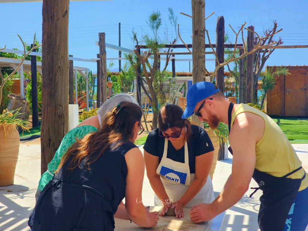 Small group learning clay preparation during a pottery class in Paros