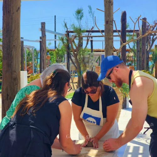 Small group learning clay preparation during a pottery class in Paros