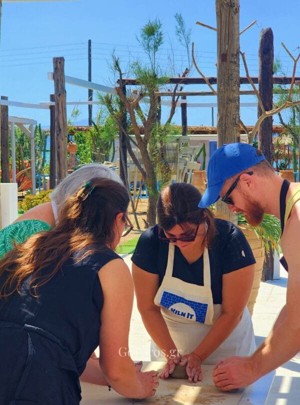 Small group learning clay preparation during a pottery class in Paros
