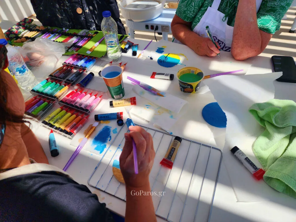 Guests painting handmade clay keepsakes during a pottery class in Paros