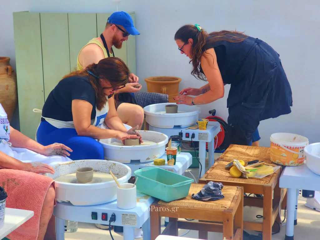 Guests learning pottery wheel techniques during a class on Golden Beach in Paros