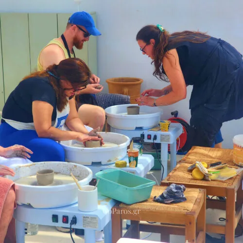 Guests learning pottery wheel techniques during a class on Golden Beach in Paros